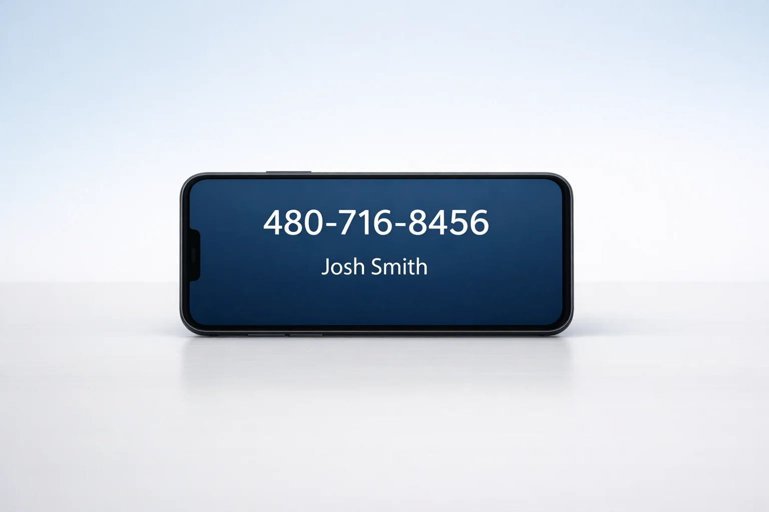 Minimalist desk with a smartphone showing 480-716-8456 and Josh Smith, simple professional design.